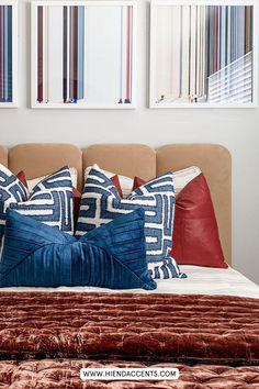 a bed with red, white and blue pillows on it's headboard in a bedroom