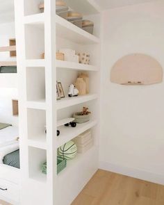 there is a bunk bed in the corner of this room with shelves on both sides