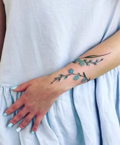 a woman's arm with blue flowers on it