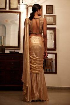 Gold pre-draped saree with all over metallic shimmery finish. Paired with sleeveless boat neck padded blouse with tonal nalki, beads, sequin floral bloom jaal embroidery.
Components: 2
Pattern: Embroidery
Type Of Work: Tonal Beads, Sequin, Nalki
Neckline: Boat Neck
Sleeve Type: Sleeveless
Fabric: Viscose Flat Chiffon Lurex , Lining: Shantoon
Color: Gold
Other Details: 
Attached inner lining
Padded blouse
Weight: 0.5kgs
Length: 42inches
Model Height: 5ft 10inches, wearing size XS
Note: The outfit Elegant Fitted Pre-draped Saree With Mirror Work, Elegant Fitted Choli With Mirror Work, Glamorous Draped Dress With Zari Work, Fitted Draped Lehenga With Mirror Work, Draped Mirror Work Fitted Choli, Fitted Draped Choli With Mirror Work, Glamorous Fitted Silk Choli, Fitted Party Top With Sheer Dupatta, Fitted Top With Sheer Dupatta For Evening