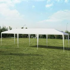 a large white tent sitting on top of a lush green field