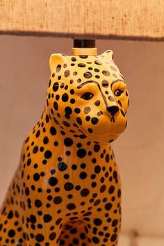 a yellow and black leopard figurine sitting next to a lamp