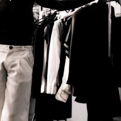 a man standing in front of a rack of clothes