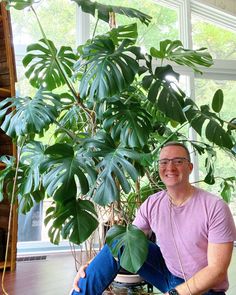 a man sitting in front of a potted plant