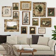 a living room filled with lots of framed pictures on the wall above a white couch