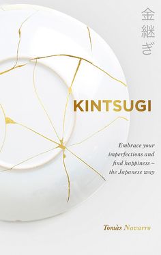 a white plate with gold lines on it and the words kintsuugi written in japanese