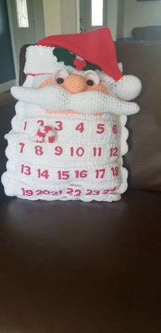 a crocheted santa clause pillow sitting on top of a couch