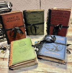 four books with ribbons tied to them sitting on a table