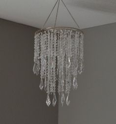 a crystal chandelier hanging from the ceiling in a room with gray walls and white trim