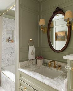 a bathroom with marble counter tops and green walls