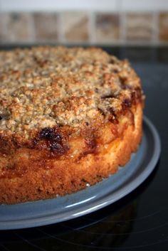 a close up of a cake on a plate on a stove top with a tile wall in the background