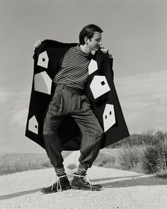 black and white photograph of a man holding an oversize jacket