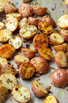 potatoes with herbs and seasoning on a baking sheet