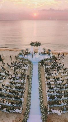 an image of a wedding ceremony on the beach with people standing in front of it