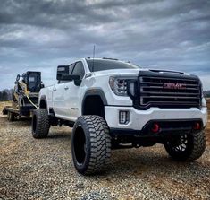 a large white truck parked on top of a gravel field