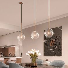 a dining room table with chairs and lights hanging from it's ceiling above it