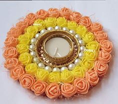 an orange and yellow rosette candle holder with pearls on it's center piece