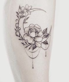 a black and white photo of a woman's thigh with a flower on it