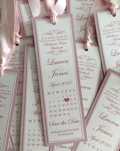 pink and white wedding programs are laid out on top of each other, with ribbons tied around them