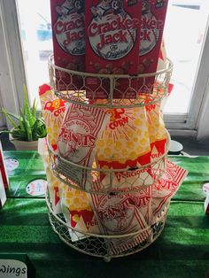 some kind of basket that is on top of a green cloth covered tablecloth with red packets in it