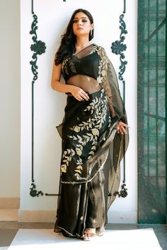 Black silk organza saree with zardosi, cutdana, beads and sequins hand embroidery. Comes with a satin silk padded blouse and a satin petticoat.
Components: 3
Pattern: Hand embroidered
Type Of Work: Zardosi, Cutdana, Beads, Sequins
Neckline: Leaf Neck
Sleeve Type: Sleeveless
Fabric: Saree : Silk organza, Blouse : Satin silk, Petticoat : Satin
Color: Black
Other Details: 
Closure : Back tie-up and hook
Occasion: Sangeet - Aza Fashions Traditional Organza Pre-draped Saree For Party, Festive Party Wear Pre-draped Embroidered Saree, Festive Party Wear Pre-draped Saree With Intricate Embroidery, Party Wear Saree With Resham Embroidery In Raw Silk, Festive Tissue Silk Blouse With Intricate Embroidery, Party Wear Blouse With Intricate Embroidery In Tissue Silk, Party Wear Blouse With Intricate Embroidery On Tissue Silk, Party Wear Saree Blouse With Intricate Embroidery, Party Wear Blouse Piece With Intricate Embroidery