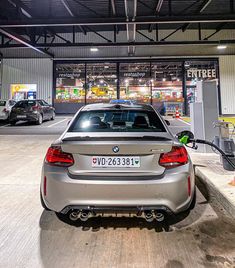 a silver car is parked in front of a gas station