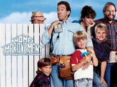 a group of people standing in front of a white picket fence with the words home improvement written on it