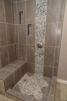 a walk in shower sitting next to a tiled wall