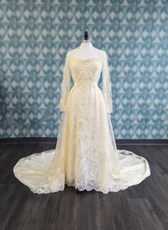 a wedding dress on display in front of a wall