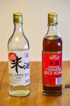 two bottles of wine sitting on top of a wooden table