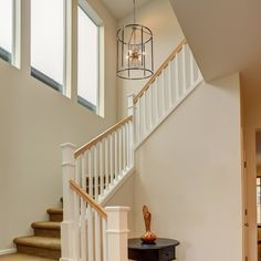 a foyer with stairs and a chandelier hanging from it's side wall