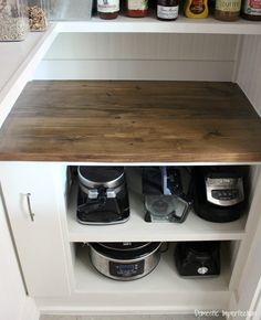 an open cabinet with coffee maker and other condiments