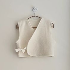 a white sweater vest hanging on a wall