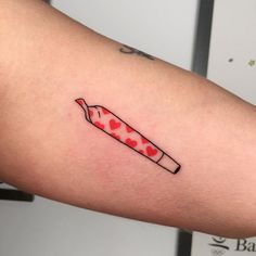 a red and white knife with hearts on it's side tattooing someones arm