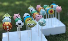 there are many cake pops on the stick in the shape of animals with different colors