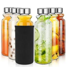 four glass jars with different types of drinks in them and one has a black lid