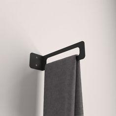 a towel hanging on the side of a white wall with a black hook in it