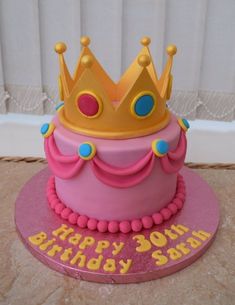 a pink birthday cake with a gold crown on top that says happy 30th birthday son