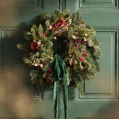 a green door with a wreath hanging on it