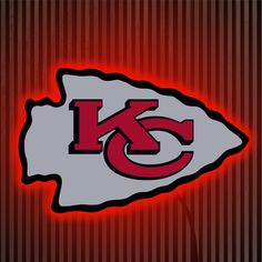 the kansas chiefs logo is lit up in red and grey colors on a striped background