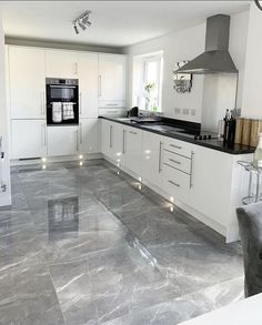 a kitchen with marble floors and white cabinets