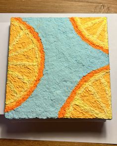 a piece of paper that has been painted with oranges and blue paint on it