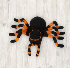 a crocheted spider with orange and black stripes