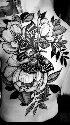 a woman's back tattoo with flowers and butterflies on her stomach, in black and white