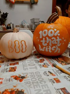 two pumpkins with the words 100 that witch painted on them sitting on a table