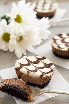 two pieces of cake sitting on top of napkins next to a flower and spoon