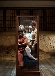 a group of people standing in front of a mirror on top of a wooden floor