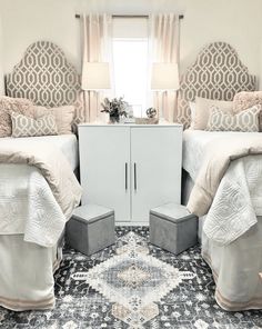 two twin beds in a bedroom with pink and white decor on the walls, along with an area rug