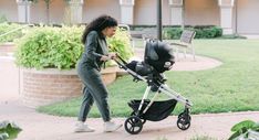 a woman pushing a stroller with a baby in it