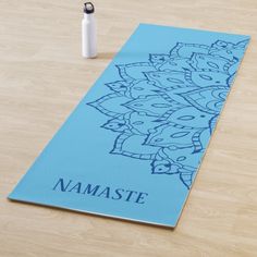 a yoga mat with namaste written on it next to a bottle of water